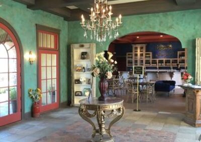 Elegant interior with a chandelier, ornate table, and colorful walls.